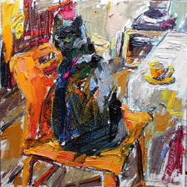Черный кот на оранжевом стуле