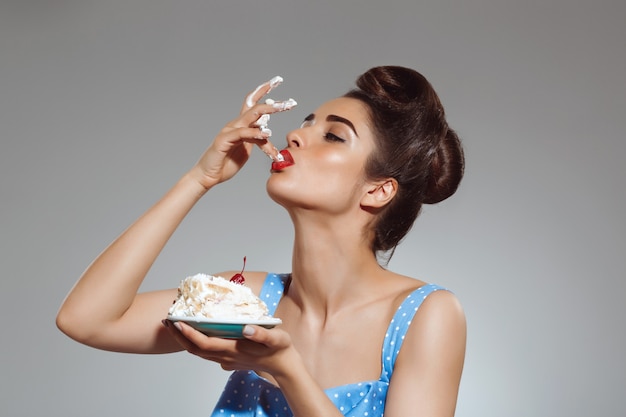 Portrait of beautiful pin up woman eating cake 176420 3339