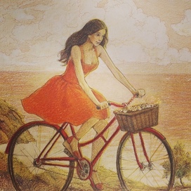 Девушка едет на велосипеде по берегу моря